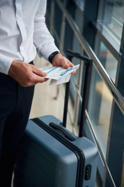 Bagajlı ve resmi elbiseli bir adamın, havaalanı seyahati kavramının yakın görüntüsü..
