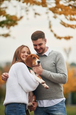 Gülümsüyor, eğleniyor. Hoş bir çift, sevimli köpekleri dışarıda..