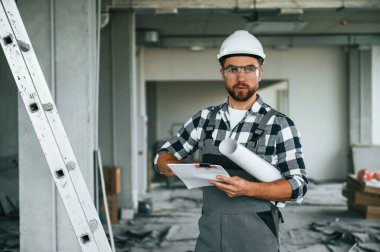 Yönetici planlarını uygulamaya koydu. Üniformalı tamirci tamamlanmamış binada..