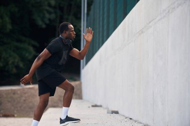 Yan görüş. Sportif siyah adam koşuyor, sabah rutini..