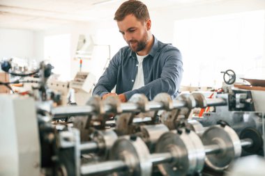 Metal yapımı makine. Yakışıklı adam ekolojik kutular üreten fabrikada çalışıyor..