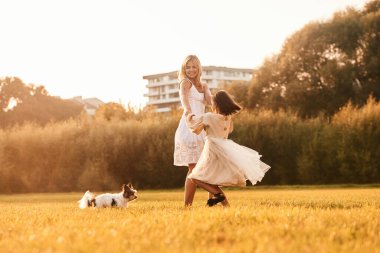 Dans etmek, eğlenmek. Anne kızıyla ve sevimli köpeğiyle açık arazide..