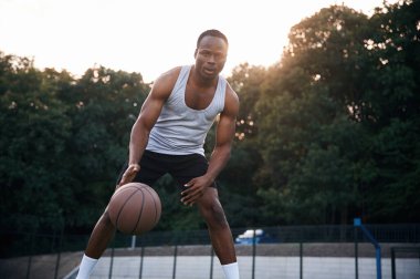 Oyun oynuyorum. Genç siyah adam basketbol topuyla dışarıda..