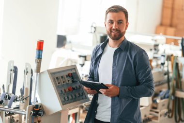 Yetenekli mühendis. Yakışıklı adam ekolojik kutular üreten fabrikada çalışıyor..