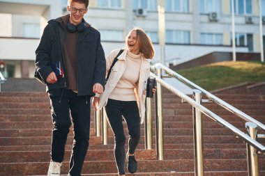 Merdivenlerde. İki genç öğrenci dışarıda birlikteler..