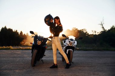 Güvenlik kavramı, koruyucu kask takmak. Dışarıda motosikletli bir kadın var..