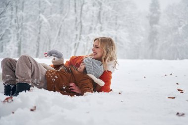 Oynamak ve eğlenmek. Anne ve kızı kış çayırlarında ve ormandalar..