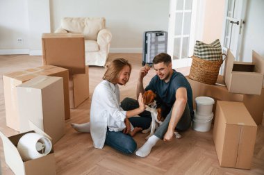 Köpekli mutlu genç çift yeni evlerine taşınıyor. Yere yat..