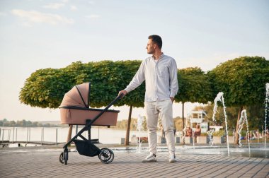 Genç baba dışarıda, bebek arabasıyla bekliyor..