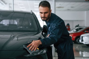 Aracı cilalıyorum. Araba tamircisi otomobille garajda..