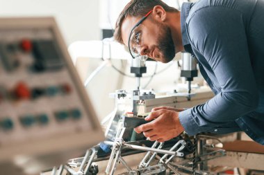 Makineyi çalıştırıyorum. Yakışıklı adam ekolojik kutular üreten fabrikada çalışıyor..