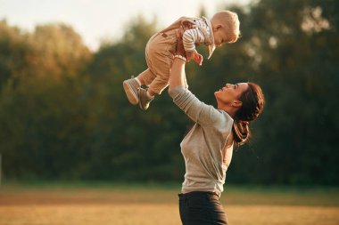 Çocuğun elini tutmak. Anne, küçük oğluyla birlikte dışarıda..