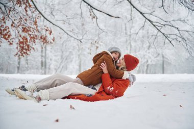 Karda uzanmak. Anne ve kızı kış çayırlarında ve ormandalar..