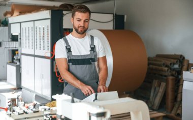 Yakışıklı adam ekolojik kutular üreten fabrikada çalışıyor..