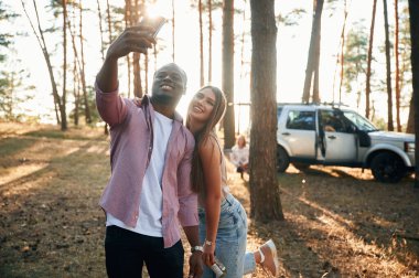 Selfie çekiyorum. Siyah adam ve beyaz kadın ormanda bir çift gibi..