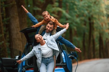 Birlikte oynuyoruz. Anne, baba ve küçük oğlu dışarıda elektrikli araba bekliyor..