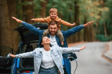 Birlikte oynuyoruz. Anne, baba ve küçük oğlu dışarıda elektrikli araba bekliyor..