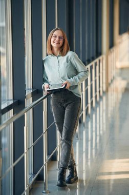 Siyah tabletli mutlu yüz ifadesi. Havaalanındaki genç bayan..