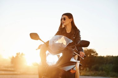 Güzel güneş ışığına karşı. Dışarıda motosikletli bir kadın var..