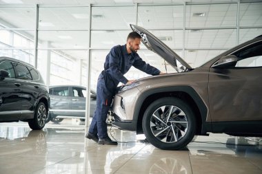 Aracı tamir etmeye odaklanmış. Araba tamircisi otomobille garajda..