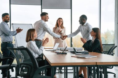 Tokalaşıyorum. Bir grup ofis çalışanı içeride birlikte..