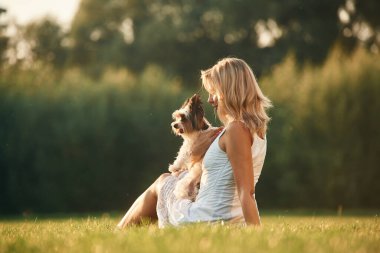 Güzel bir kadın, sevimli köpeğiyle birlikte sahada..