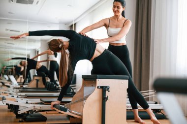 Omurga germeyi öğretiyorum. Spor salonundaki kadınlar egzersiz yapıyor..