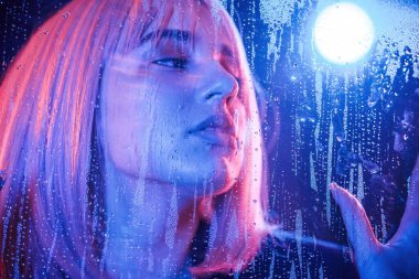 Poz, sakince yüz ifadesi. Beyaz saçlı şık kadın ıslak şeffaf plastik çarşafın arkasında..