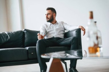 Resmi kıyafetlerle. İş başarısızlığı. Alkolik genç adam içeride..