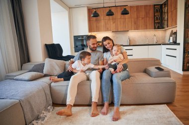 Ön manzara. İki küçük çocuklu ebeveynler evcil odada birlikteler..