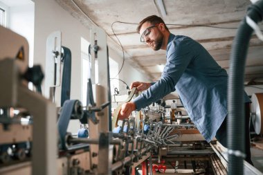 Bekar bir çalışan. Yakışıklı adam ekolojik kutular üreten fabrikada çalışıyor..
