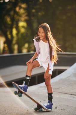 Rampada. Dışarıda kaykaylı mutlu küçük kız.