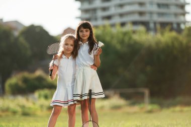 Kızlar ayakta ve poz veriyor. Mutlu çocuklar yaz tarlasında.