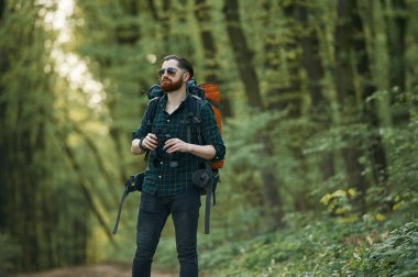 Dürbünle yoldayız. Sakallı adam gündüz vakti ormandadır..