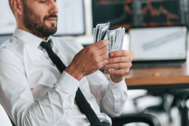 Para sayıyor. İşadamı bilgisayar başında oturuyor ve ofiste çalışıyor..