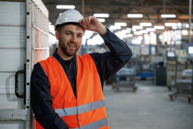 Duvara yaslan. Fabrika işçisi kasketli bir şekilde içeride..