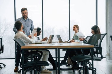 Masada bir sürü dizüstü bilgisayar var. Ofis çalışanlarından oluşan ekip içeride bir arada..