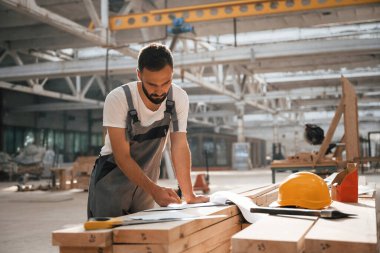 Bir sürü kağıt ve plan. Ahşap depoda sanayi işçisi..