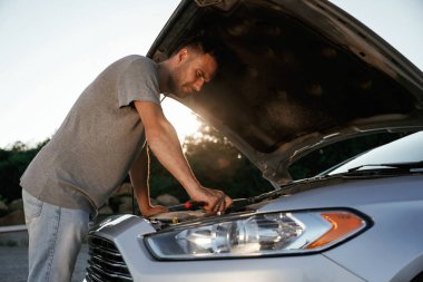 Kaput açıldı, tamir ediliyor. Adam dışarıda arabasıyla bekliyor..