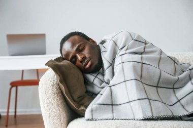 Kanepeye uzanıyordu. Hasta siyah adam evde..