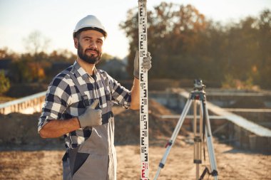 Beyaz kasketli. İşçi gündüz vakti şantiyede..