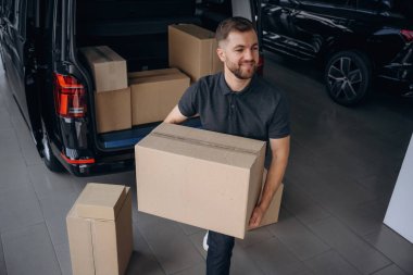 Kutuları boşaltıyorum. Teslimatçı ya da yükleyici arabanın yanında..