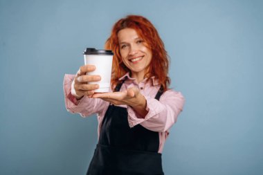 Beyaz kağıt bardakta taze içecek. Kadın stüdyoda arka planda..