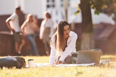 Güneş ışığı, kadını aydınlatıyor. Bir grup öğrenci birlikte dışarı çıktılar..
