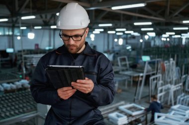 Tabletteki verileri okuyorum. Fabrika işçisi kasketli bir şekilde içeride..