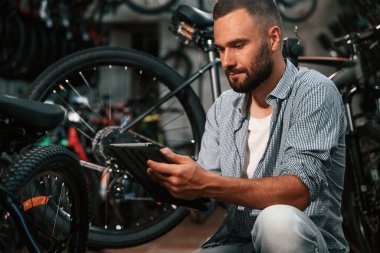 Dijital tablet kullanılıyor. Bisiklet dükkanında tamirci, mağazada çalışıyor..