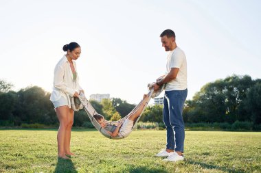 Battaniye, onunla oynuyor. Anne ve baba oğluyla birlikte dışarıda, tarlada..