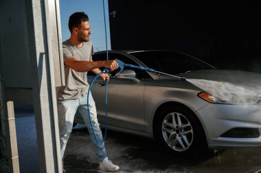 Araba yıkama servisi, adam dışarıda arabasıyla bekliyor..