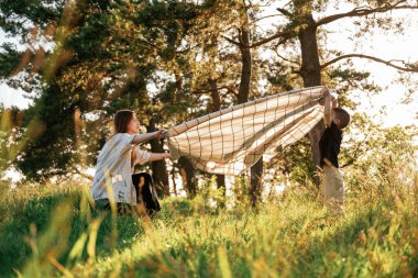 Battaniyeli, yere koyuyor. Anne ve oğlu ormanda beraberler..
