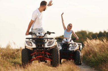 Açık kırsal yolda. Erkek ve kadın dışarıda ATV 'deler..